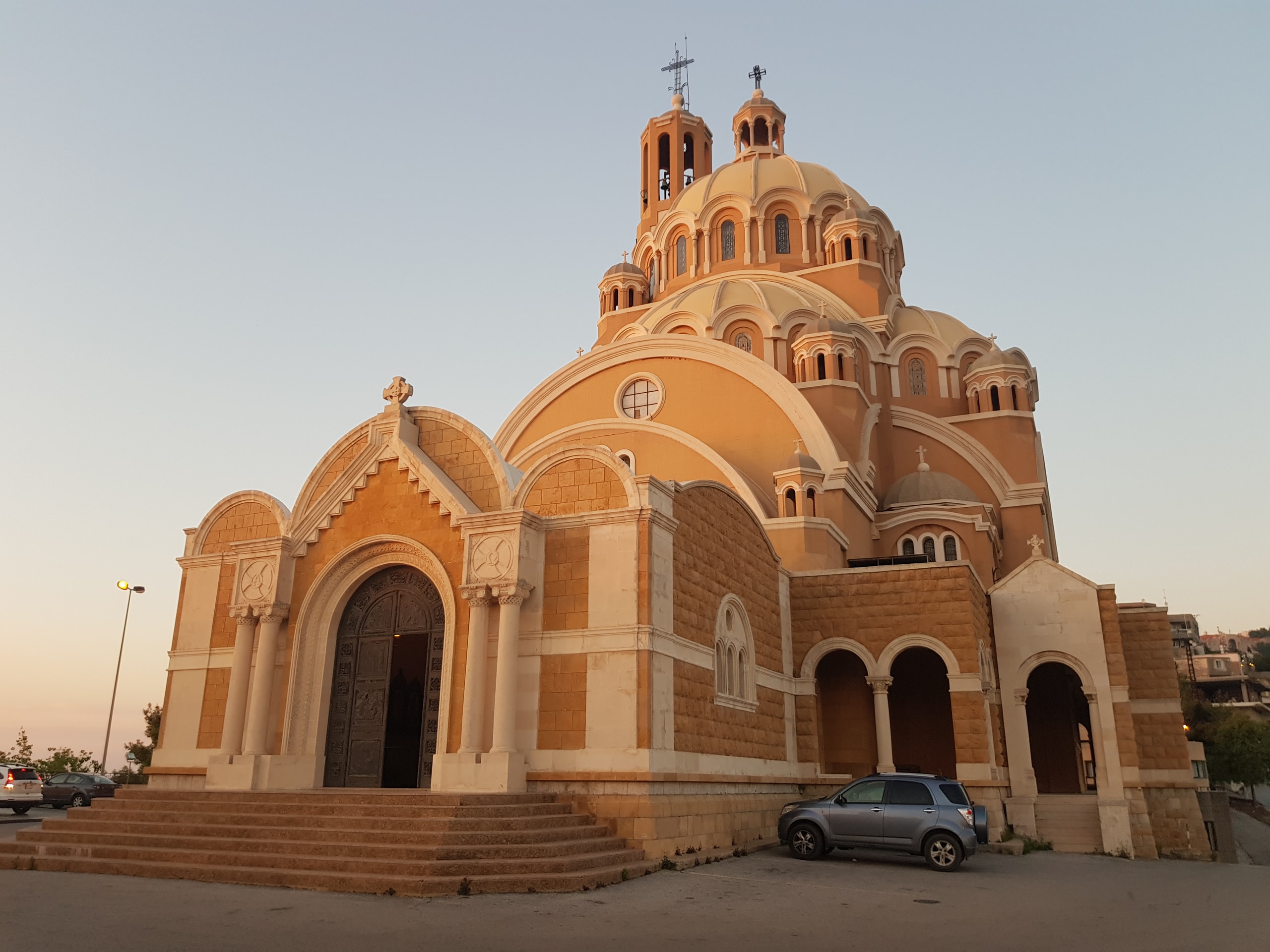 Domed cathedral with crosses glowing in warm evening light